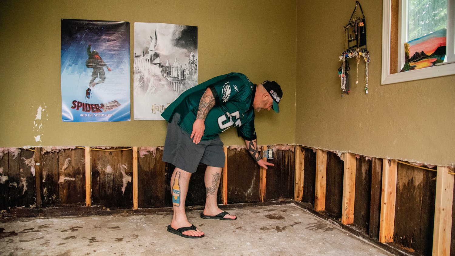Keith Pardue points out how high the flood water reached inside his daughter's room Sunday along Ceres Hill Road in Chehalis.