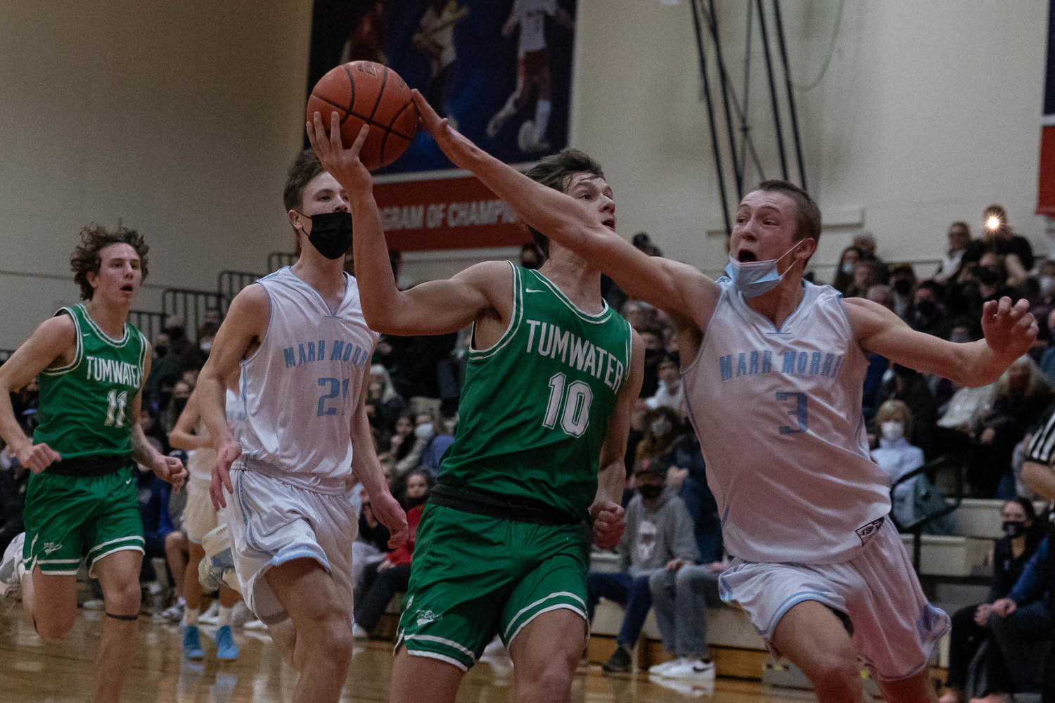 Tumwater guard Andrew Collins drives for a layup while Mark Morris guard Deacon Dietz stretches for a strip at the MLK Tribute in Longview at Lower Columbia Community College Jan. 17.