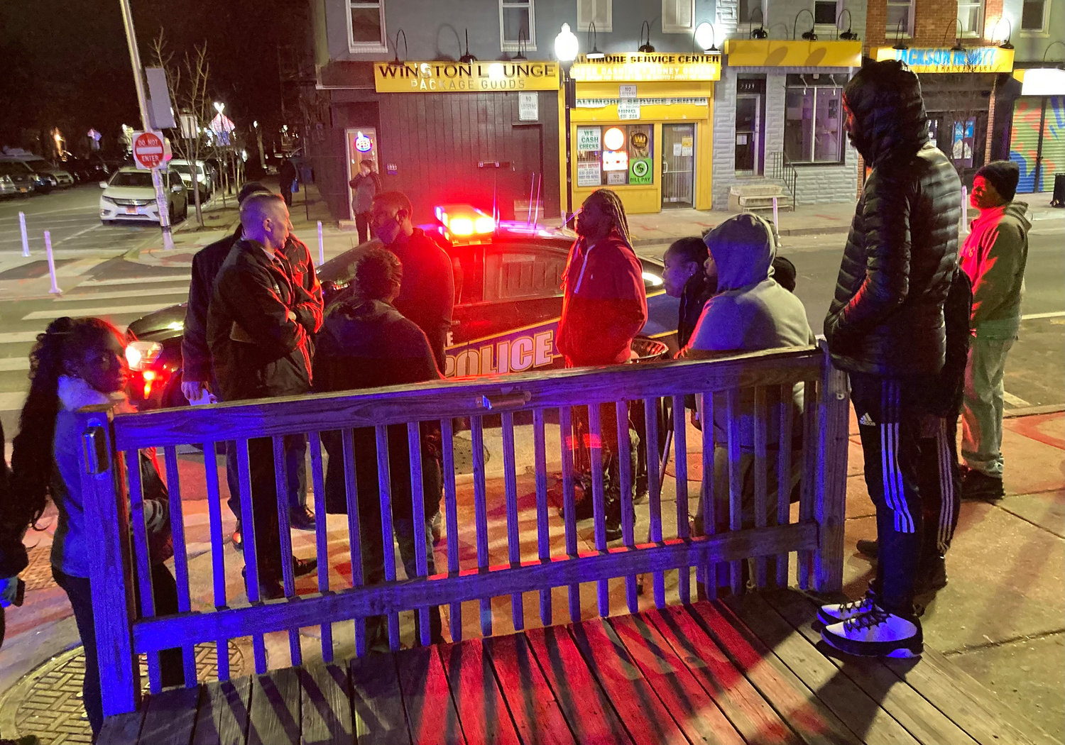 An officer talks with people near scene of shooting in 2400 block of East Monument Street, East Baltimore, on Wednesday, Jan. 19, 2022. (Amy Davis/The Baltimore Sun/TNS)
