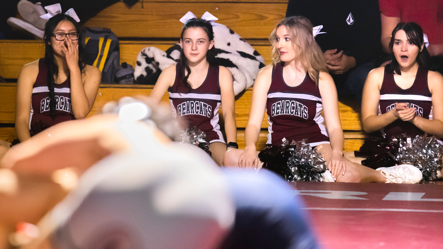 Cheerleaders react as wrestlers hit the mat Thursday night at W.F. West High School.