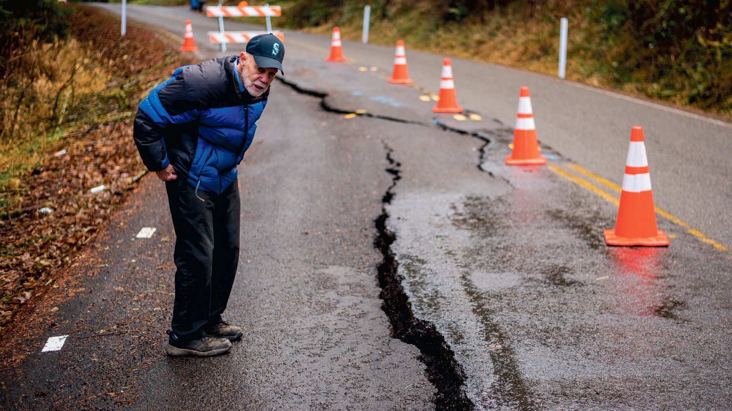 FILE PHOTO — Erik Dahl looks down at a crack which continues to form in the 2100 block of Little Hanaford Road in Centralia in January.