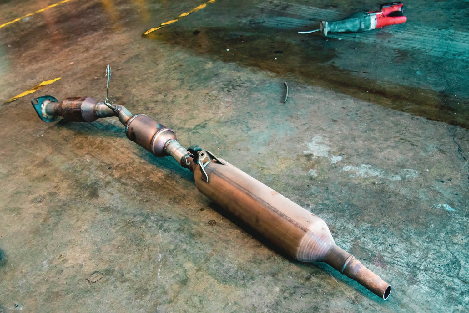 FILE PHOTO — A catalytic converter from a hybrid Prius lays on the floor next to an electric reciprocating hand saw.