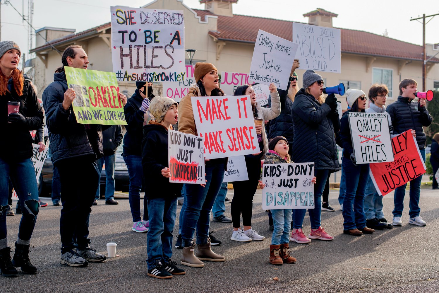 Kent Cooperrider, Oakley’s foster grandpa, and foster mom Jaime Jo Hiles stand alongside demonstrators with signs and megaphones outside the Grays Harbor County Correctional Facility Saturday in Montesano.