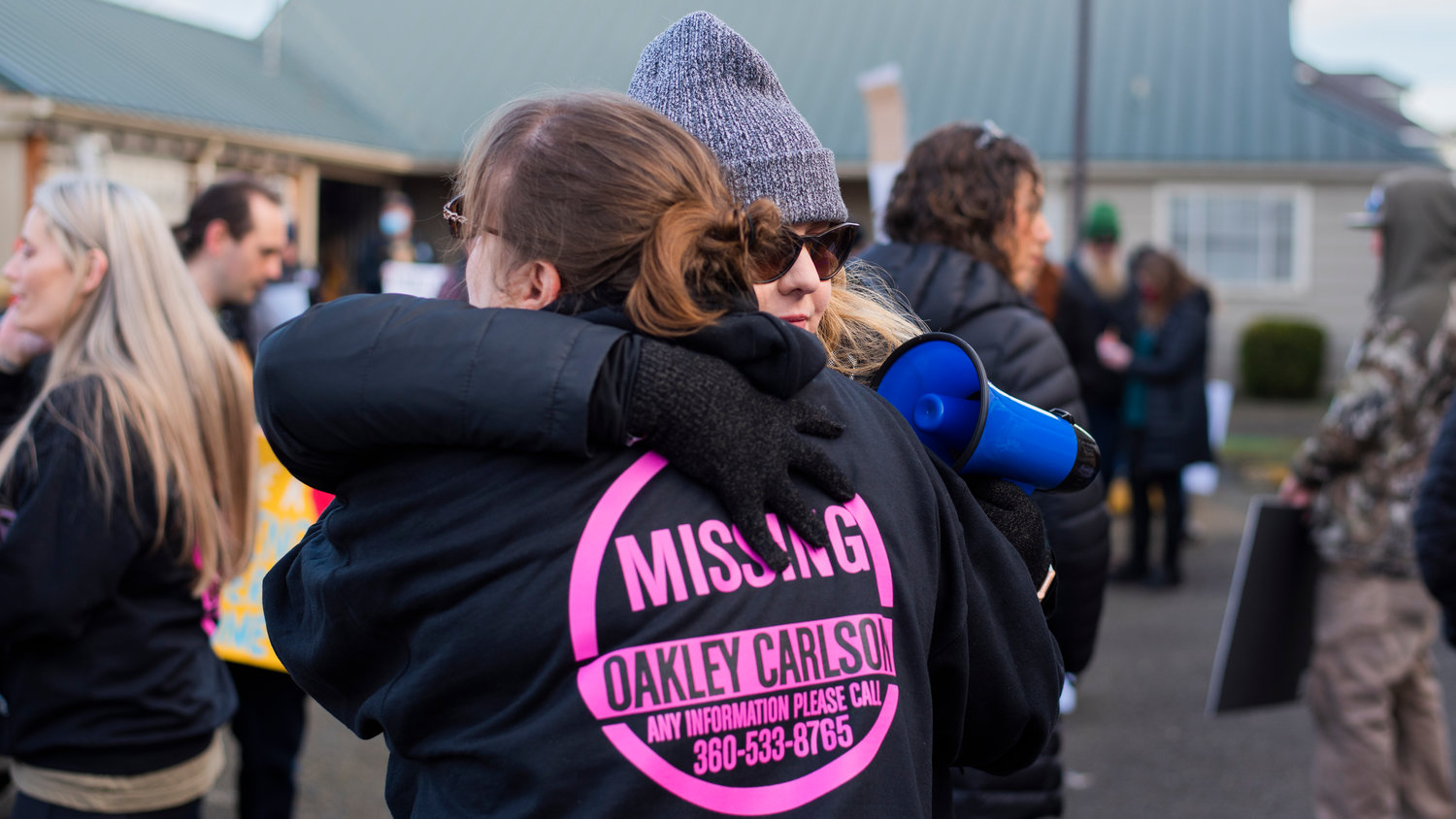Foster mom Jaime Jo Hiles receives an embrace as demonstrators hold signs and chant outside the Grays Harbor County Correctional Facility Saturday in Montesano.