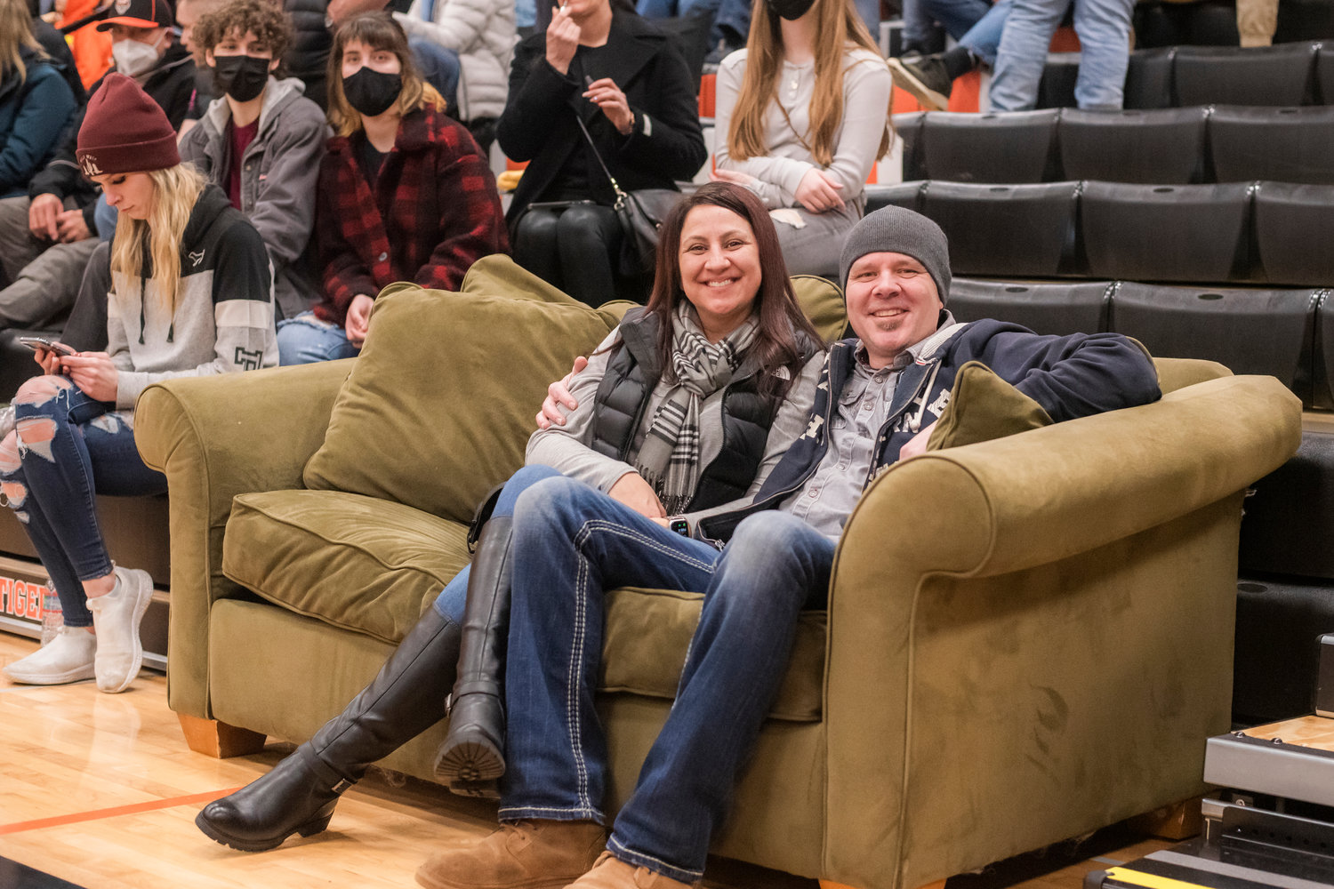 Hobe and Shoni Pannkuk smile and pose for a photo courtside on a couch Friday night at Centralia High School during a boys basketball game.