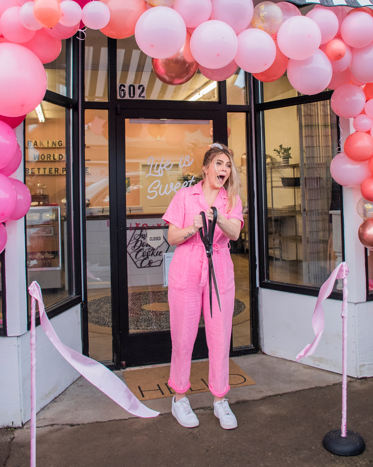 Ashlee Shirer, owner of Sweet Dough Cookie Co., reacts as she cuts a ribbon during ceremony outside her Centralia storefront Saturday morning.