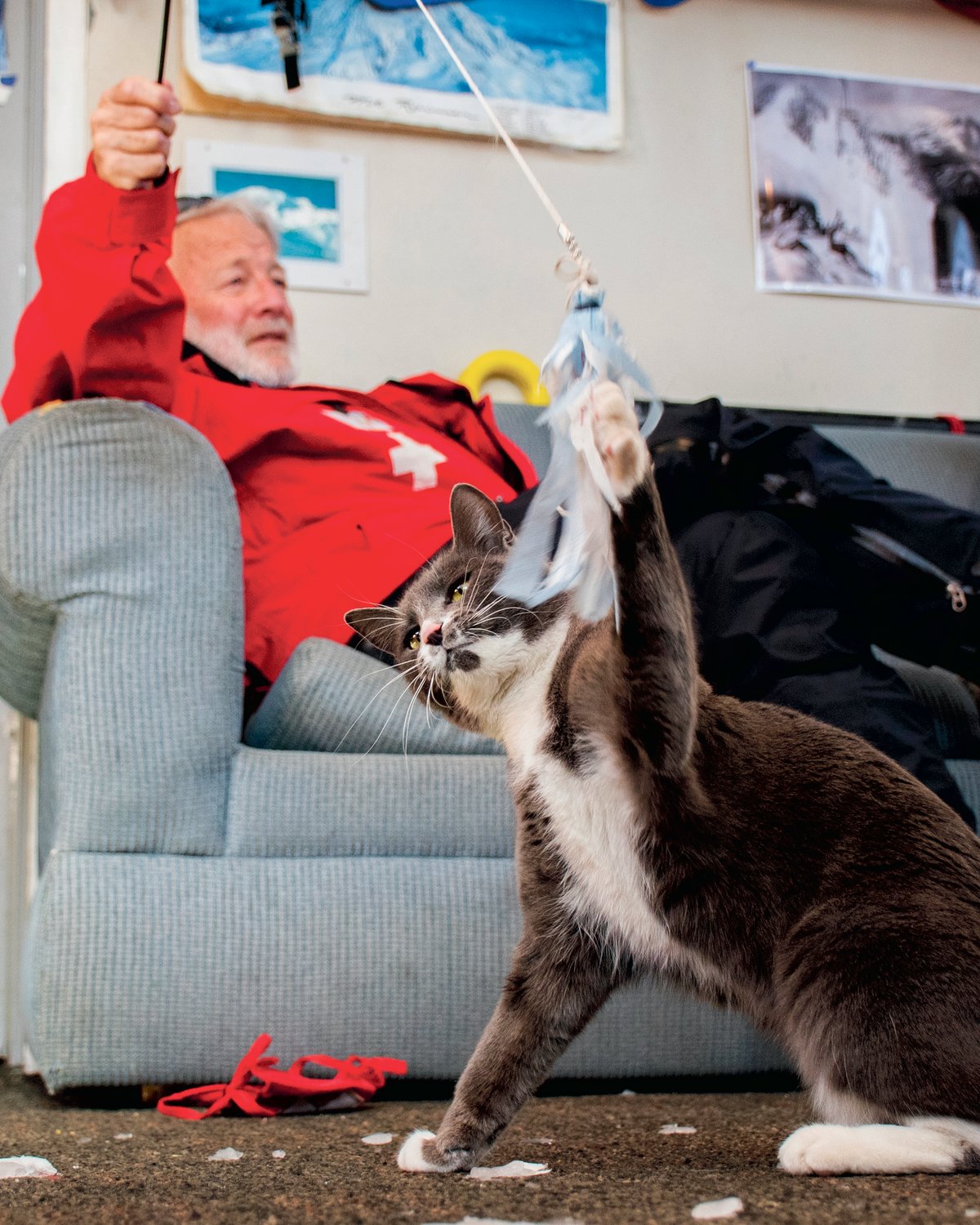 Michael “Murph” Murphy talks about his time with Ski Patrol at White Pass while holding a cat toy that Uzi swats inside patrol dispatch at the top of the Great White Express chairlift on Sunday.