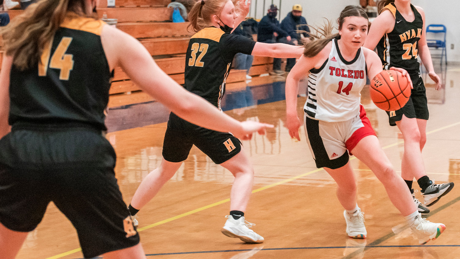 Toledo’s Hope Gould (14) dribbles around Hyak defenders during a game at Rochester High School Tuesday night.