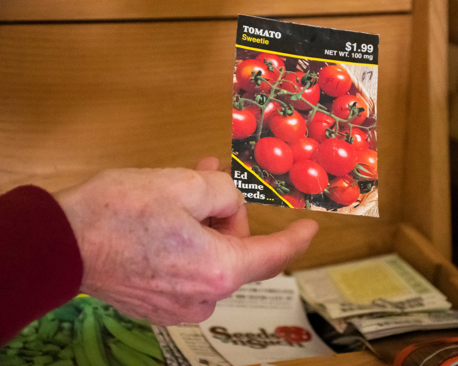 Gayle Schilling holds up a packet of seeds from a box Tuesday morning in her home.