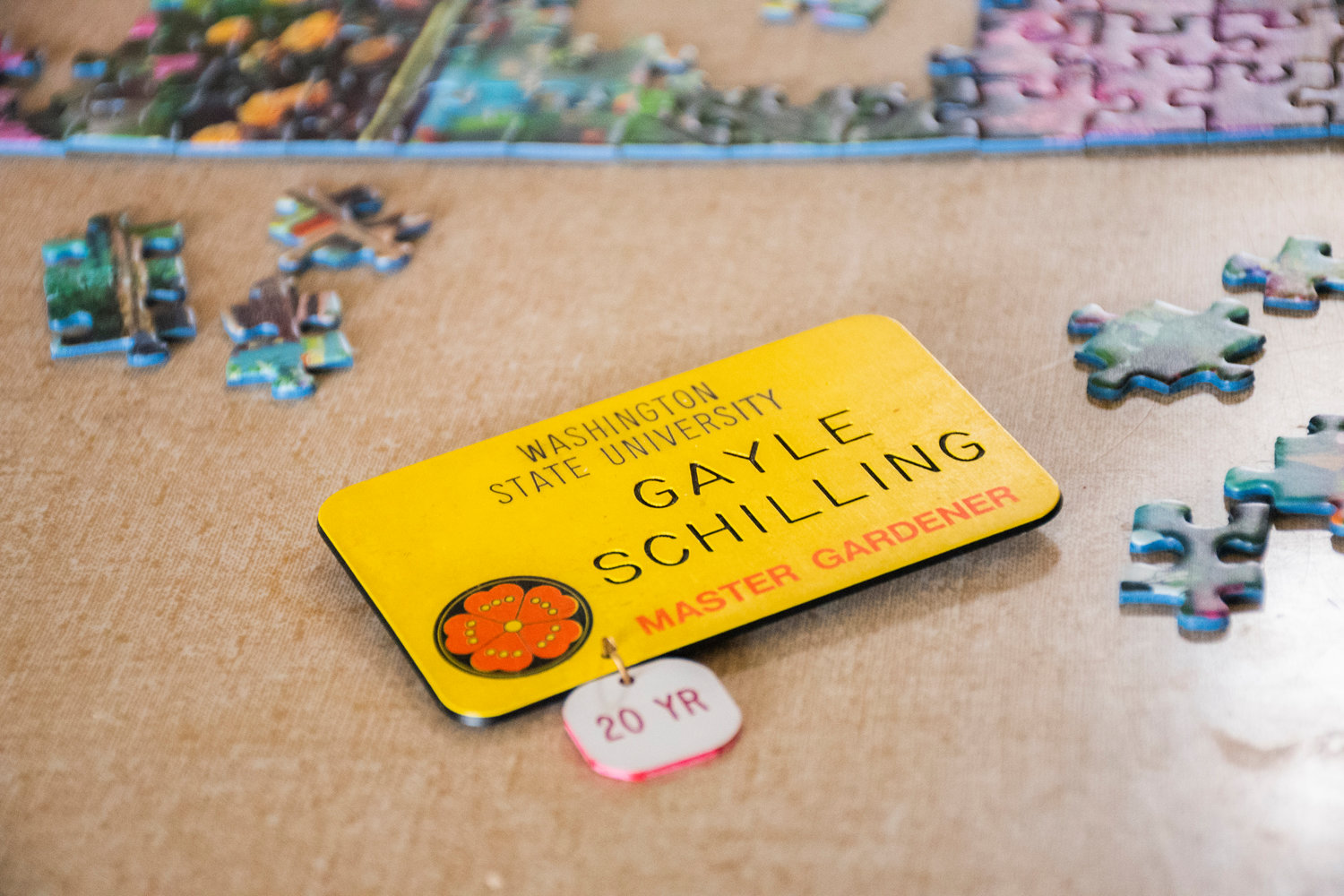 Gayle Schilling’s nametag sits on a table next to an unfinished puzzle of a garden Tuesday at her residence.