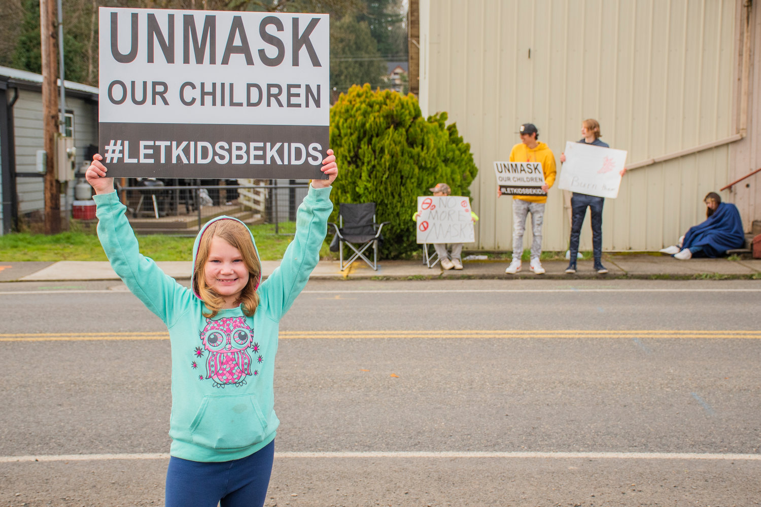Clair Root, 7, stands with a sign along Southwest Kerron Street as students protest the mask mandate Tuesday afternoon in Winlock.