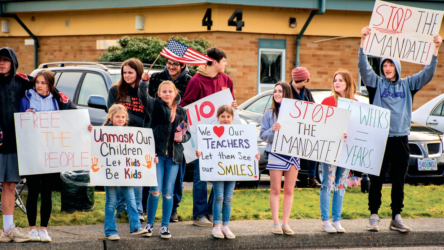 Students in the Onalaska School District stand outside waving signs and flags during a protest along Carlisle Avenue Wednesday morning.