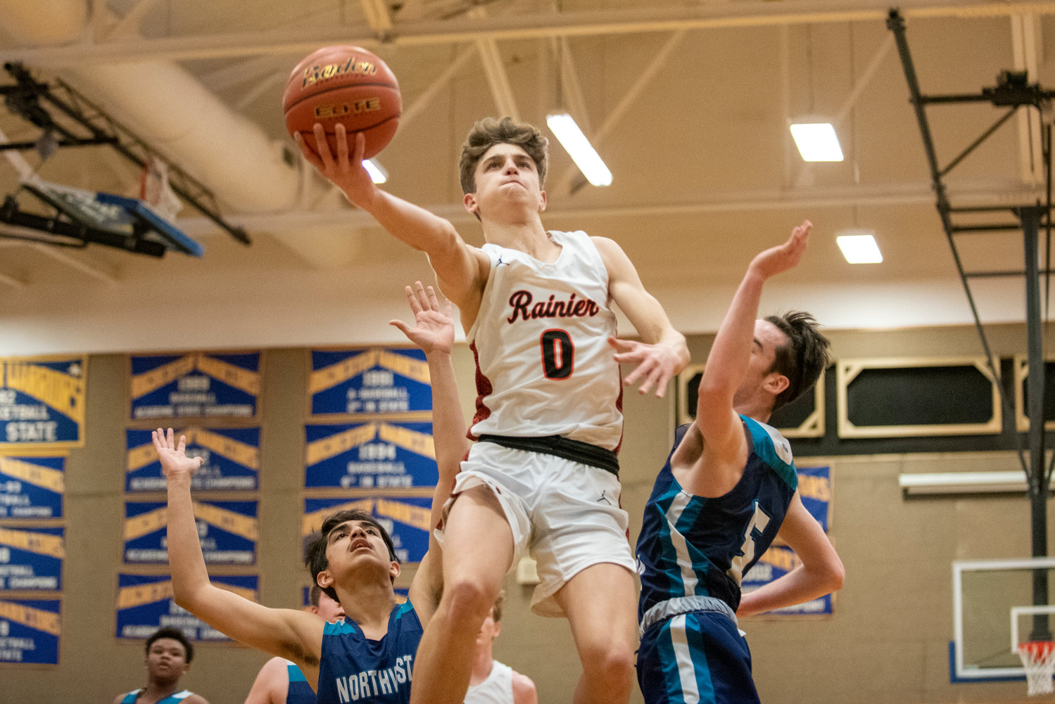 Rainier senior Ian Sprouffske (0) drives for a layup in a win over Northwest Christian (Lacey) in the district playoffs on Feb. 9 at Rochester High School.