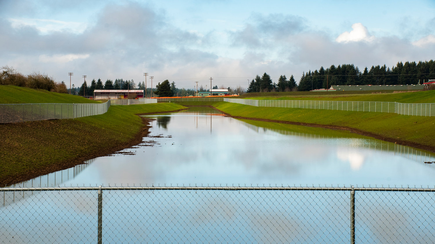 The Winlock High School football stadium sets the backdrop for a water retention pond in Winlock off Mickelsen Parkway.