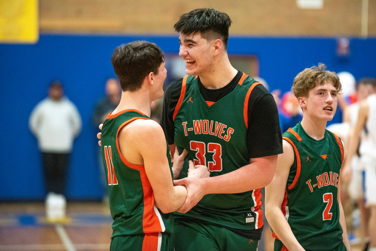 Morton-White Pass' Josh Salguero (33), Hunter Hazen (11) and Judah Kelly (2) celebrate after the Timberwolves defeat Adna in the distrist semifinals Wednesday at Kelso High School.