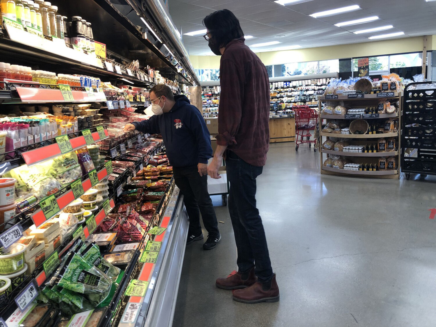 An employee assists Will Butler, 31, find the type of steak he wants at the grocery store in Silverlake on Thursday, Jan. 21, 2021, in Los Angeles, California. (Dania Maxwell/Los Angeles Times/TNS)