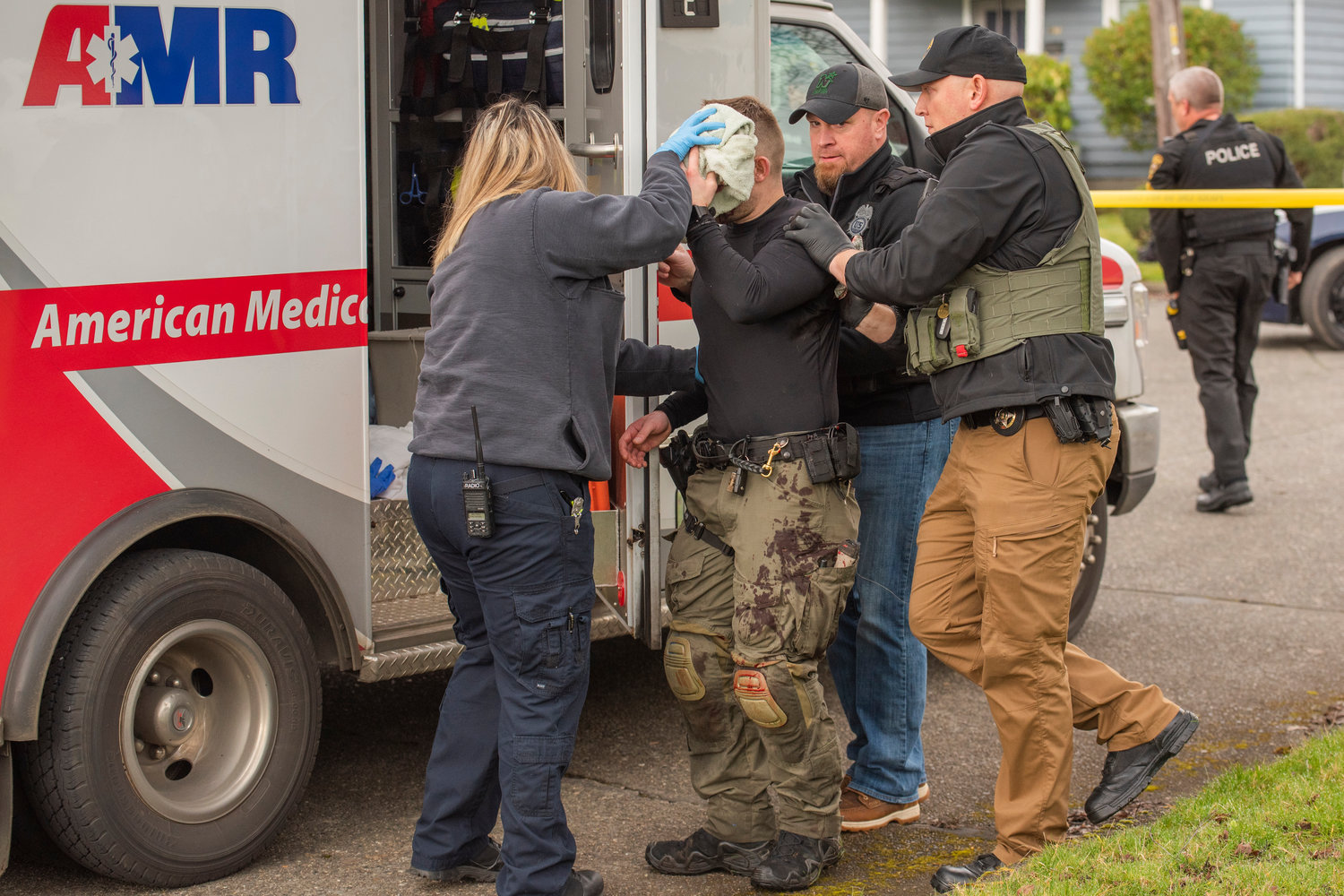 Officer Stephen Summers is treated for injuries and helped into the back of an ambulance in the 100 block of Southwest Alfred Street in Chehalis.