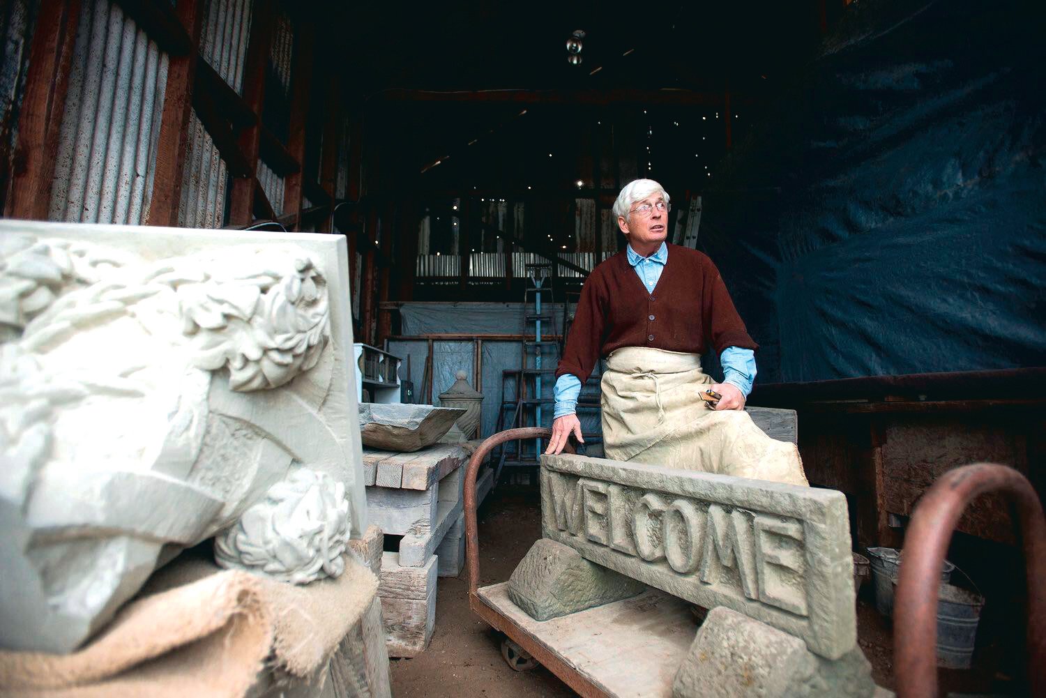 Surrounded by intricately carved pieces of sandstone, Keith Phillips, a master stonecutter, stands inside a rustic shed in downtown Tenino in this Chronicle file photo.