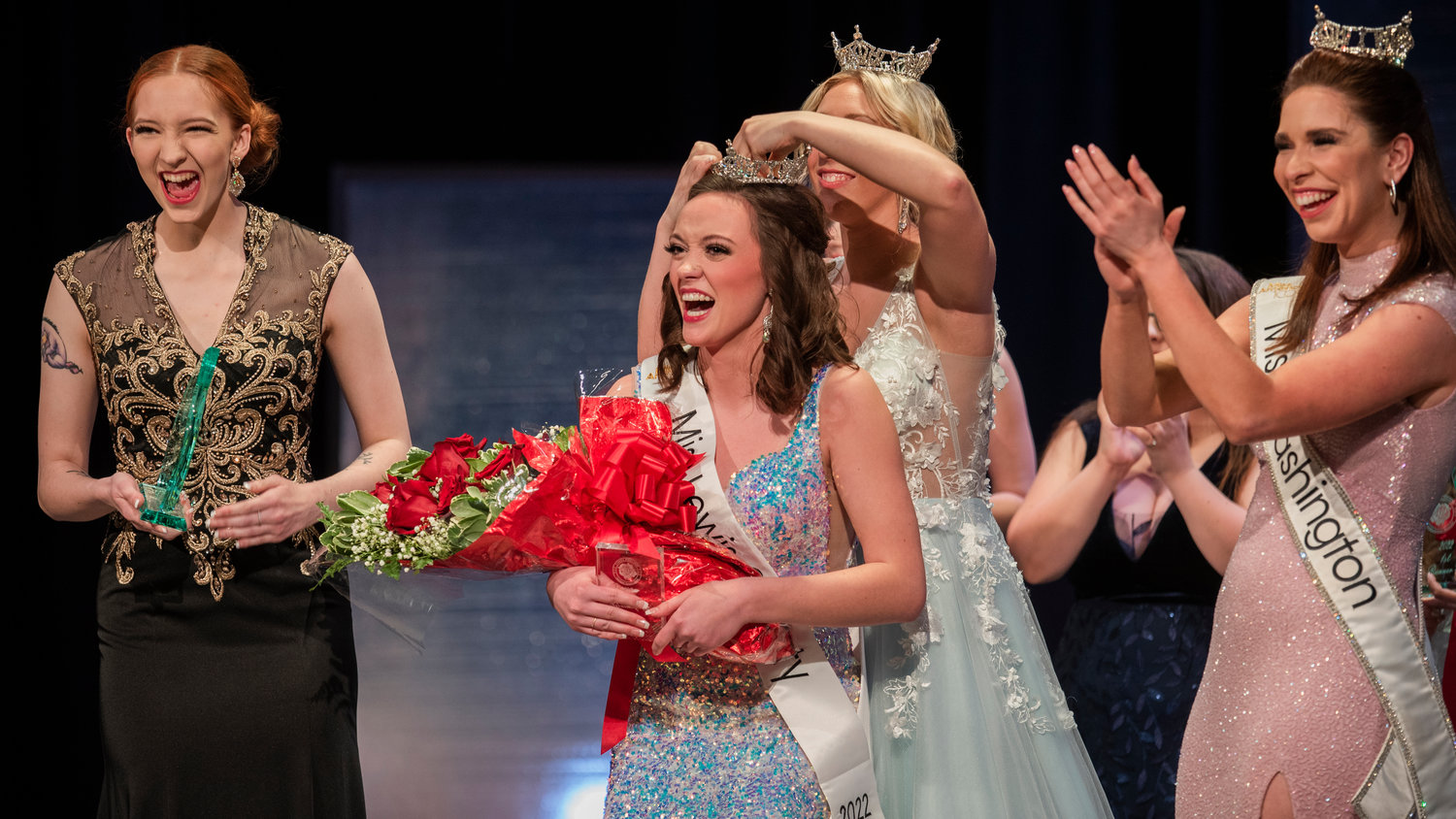Briana Rasku reacts to being crowned Miss Lewis County by Sophie Moerke while surrounded by former crown holder Angela March and Miss Washington Maddie Louder during an event held at Centralia High School Saturday night.
