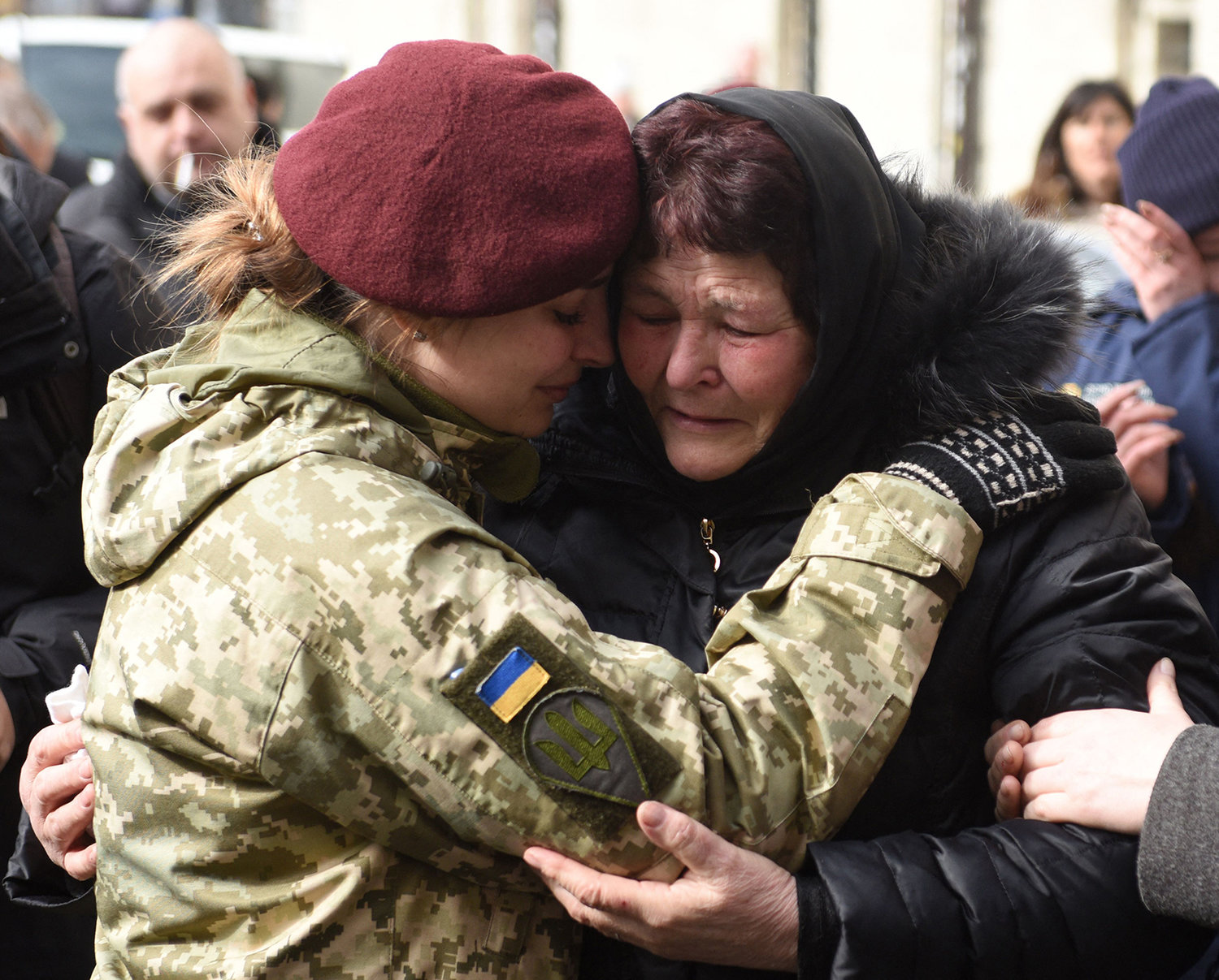 A servicewoman reacts during funerals of Dmytro Kotenko, Vasyl Vyshyvany and Kyrylo Moroz, Ukrainian servicemen killed during Russia's invasion of Ukraine, in the western Ukrainian city of Lviv on March 9, 2022. (Yuriy Dyachyshyn/AFP via Getty Images/TNS)