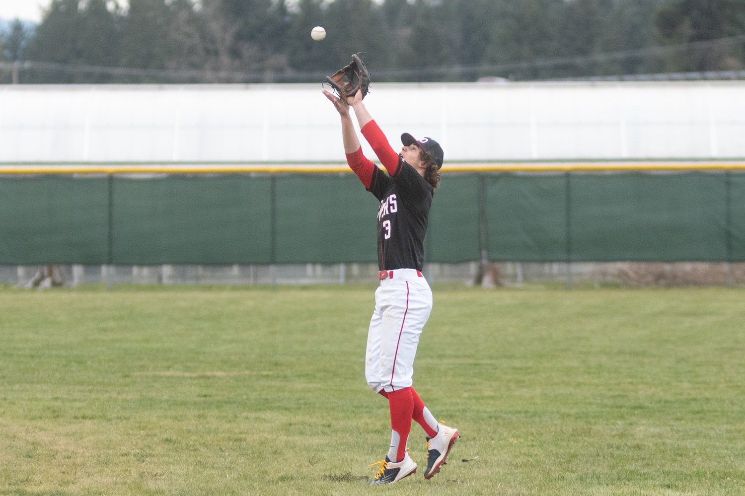 Easton Snider reaches up for a fly ball against Rochester in the Scatter Creek Derby March 12.