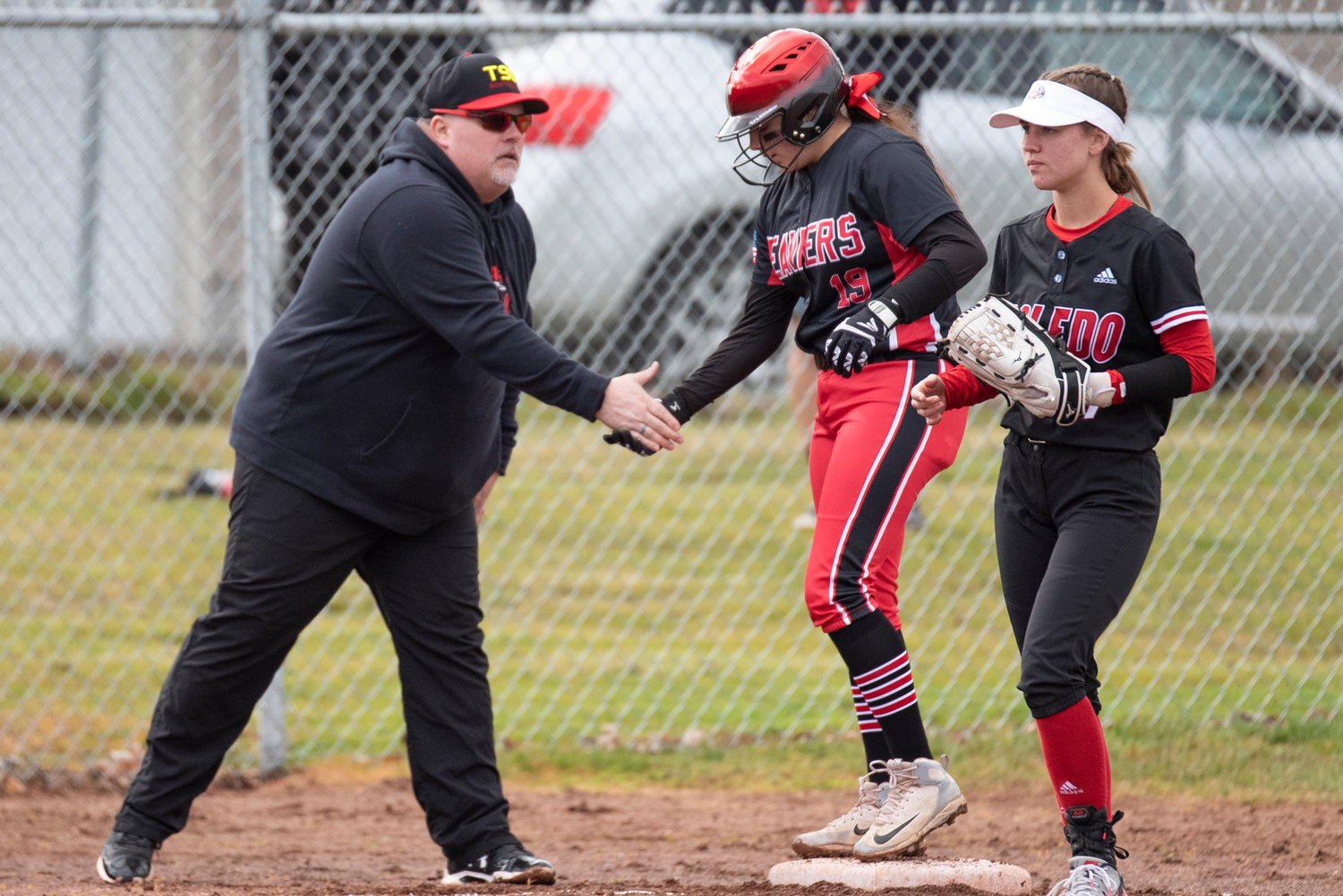 Tenino coach high-fives Kiyah Goodwin during a home game against Toledo on March 16.