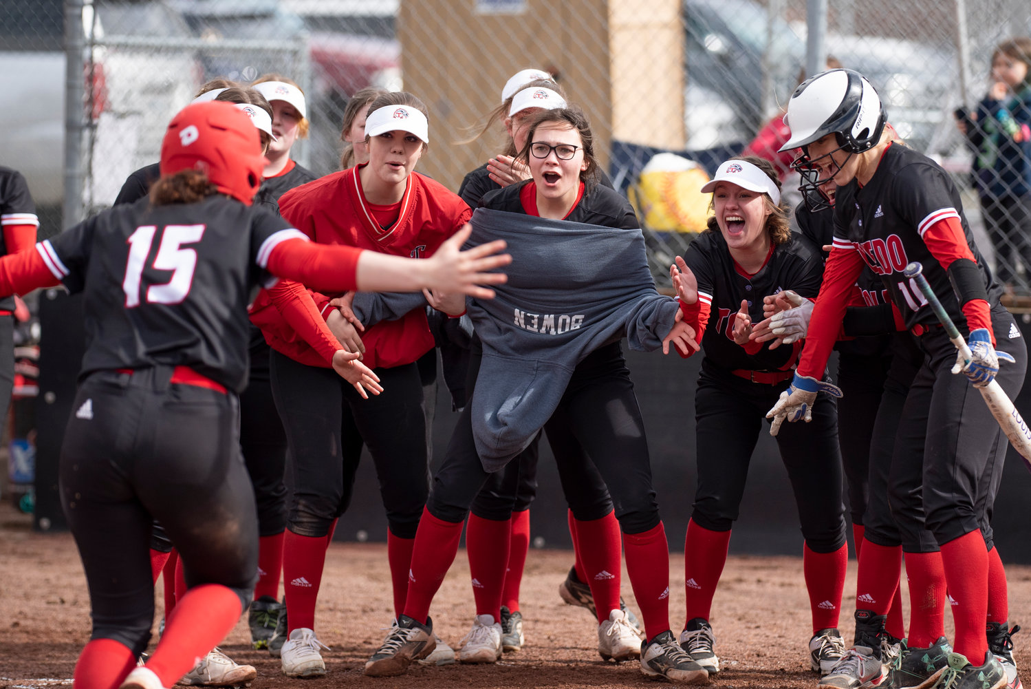 Toledo players greet Abbie Marcil at home plate after Marcil hit a home run on the road against Tenino on March 16.