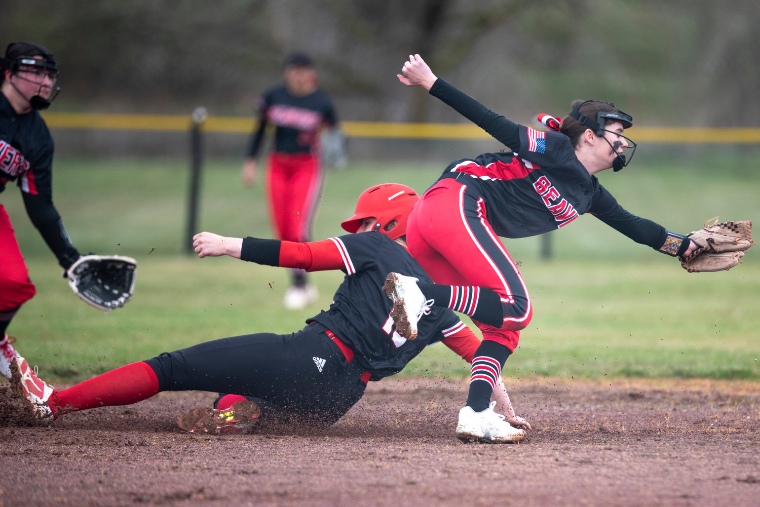 Tenino's Kayla Feltus, right, dives for a throw from the Beavers' catcher as a Toledo baserunner slides safely into second base on March 16.