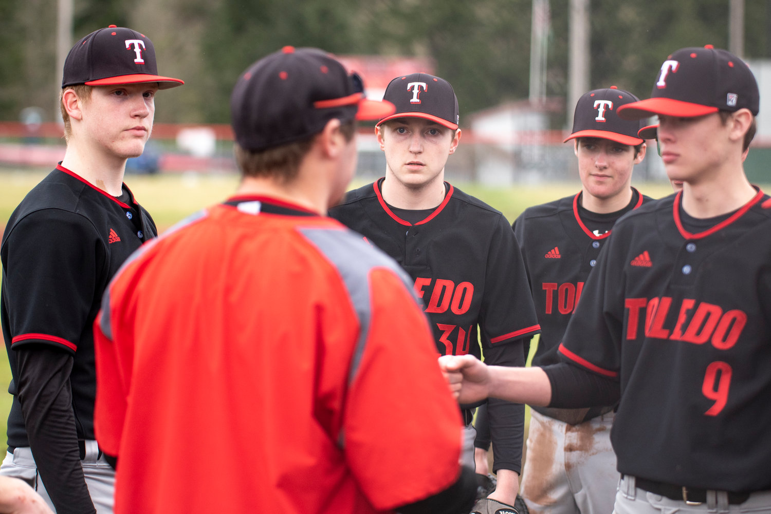 Toledo baseball coach Mack Gaul, foreground, talks to his team between innings during a road game at Tenino on March 16.
