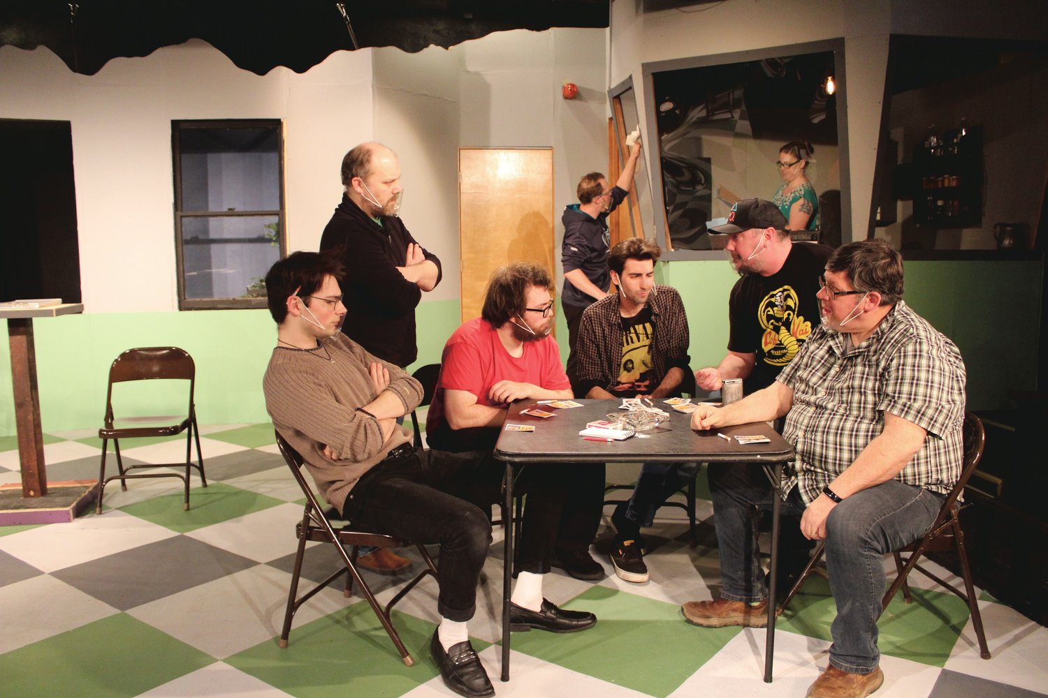 Randle P. McMurphy (portrayed by Ryan Holmberg) plays cards with fellow residents (from left to right) Cheswick (portrayed by Jordan Baker), Dale Harding (portrayed by Isaac McKenzieSullivan), Scanlon (portrayed by Nick Hall), Billy Bibbit (portrayed by Chris Bolduc) and Martini (portrayed by Dave Marsh) as Aide Warren (portrayed by Steven Walker) and Nurse Ratched (portrayed by Danielle Kays) look on in "One Flew Over the Cuckoo's Nest" opening at Centralia's Evergreen Playhouse Friday.