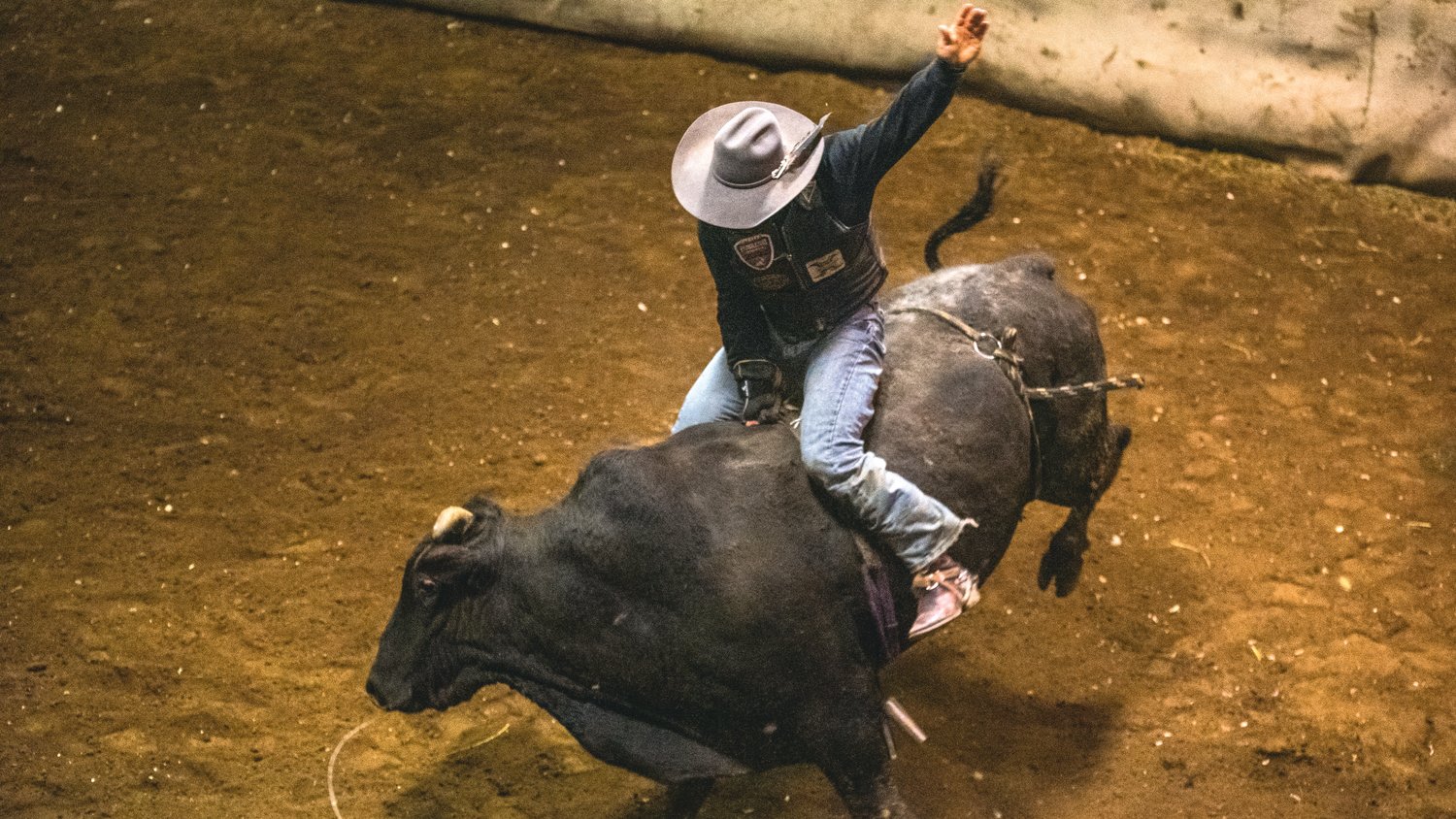 Marc Dorendorf sports a cowboy hat tries to hang onto a bull at a Lazy HK Bar Rodeo Winter Series event Saturday in Silver Creek.