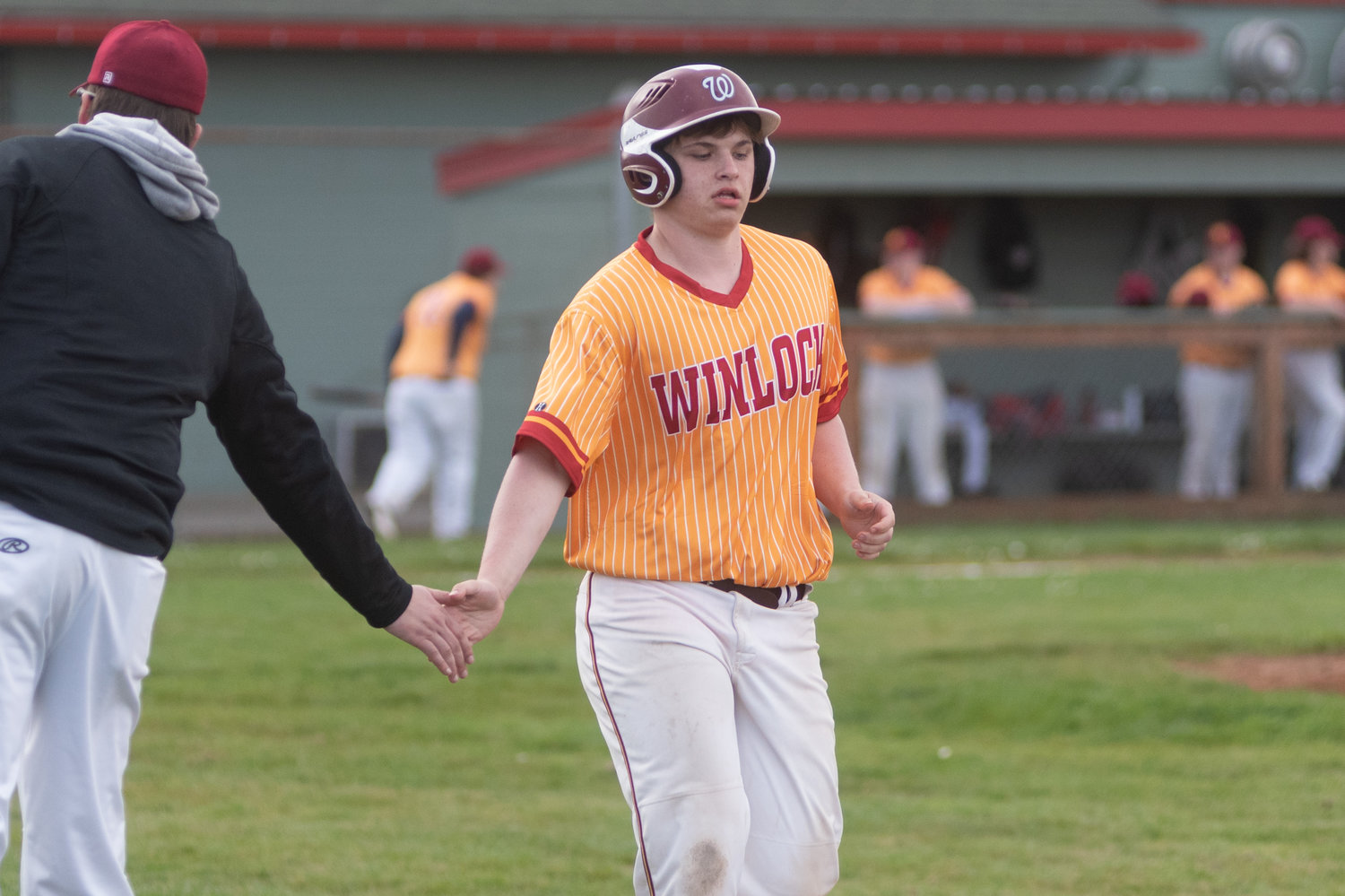 Winlock second baseman Cole Fray-Parmantier high-fives his coach after drawing a walk against Stevenson March 28.