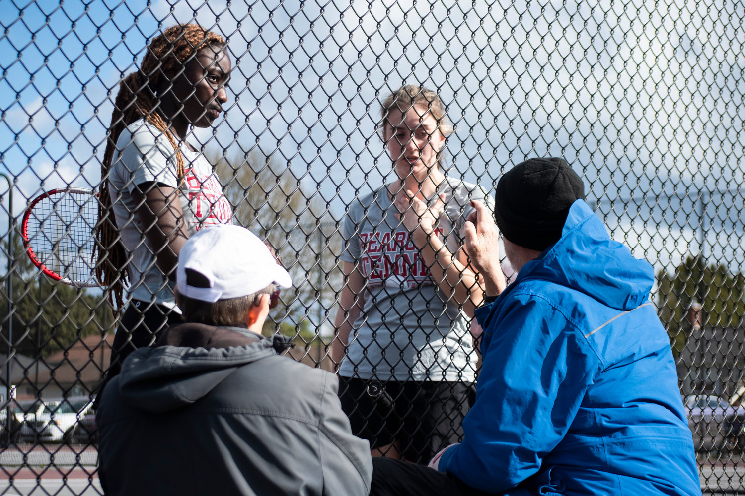 W.F. West’s first doubles team Mariama Ceesay (left) and Kaylynne Dowling are coached in between sets by coach Jack State and assistant coach Denise Boulac on Wednesday in Chehalis.