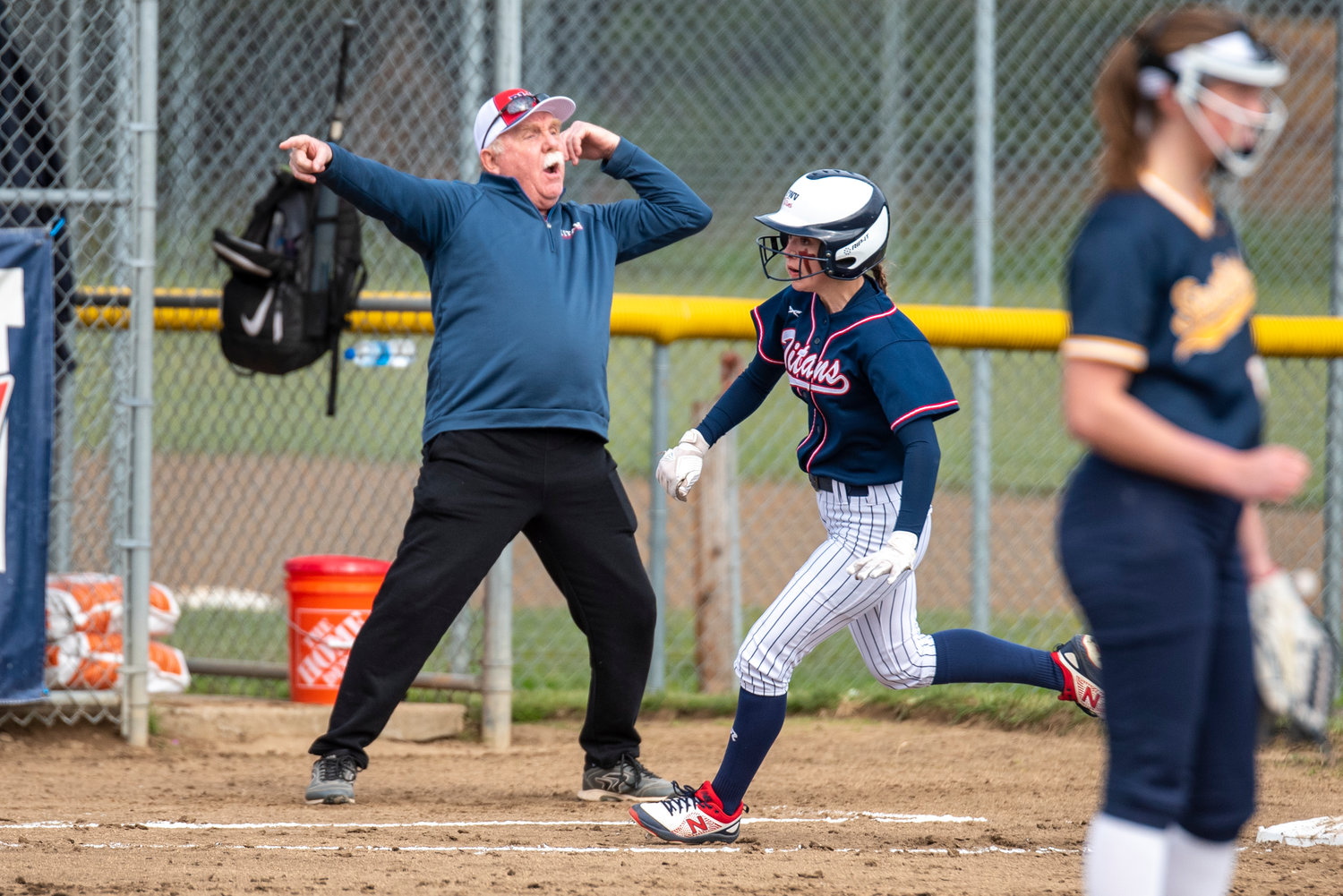 Pe Ell-Willapa Valley coach Ken Olson waves Lauren Matlock home during a home game against Forks on April 1.