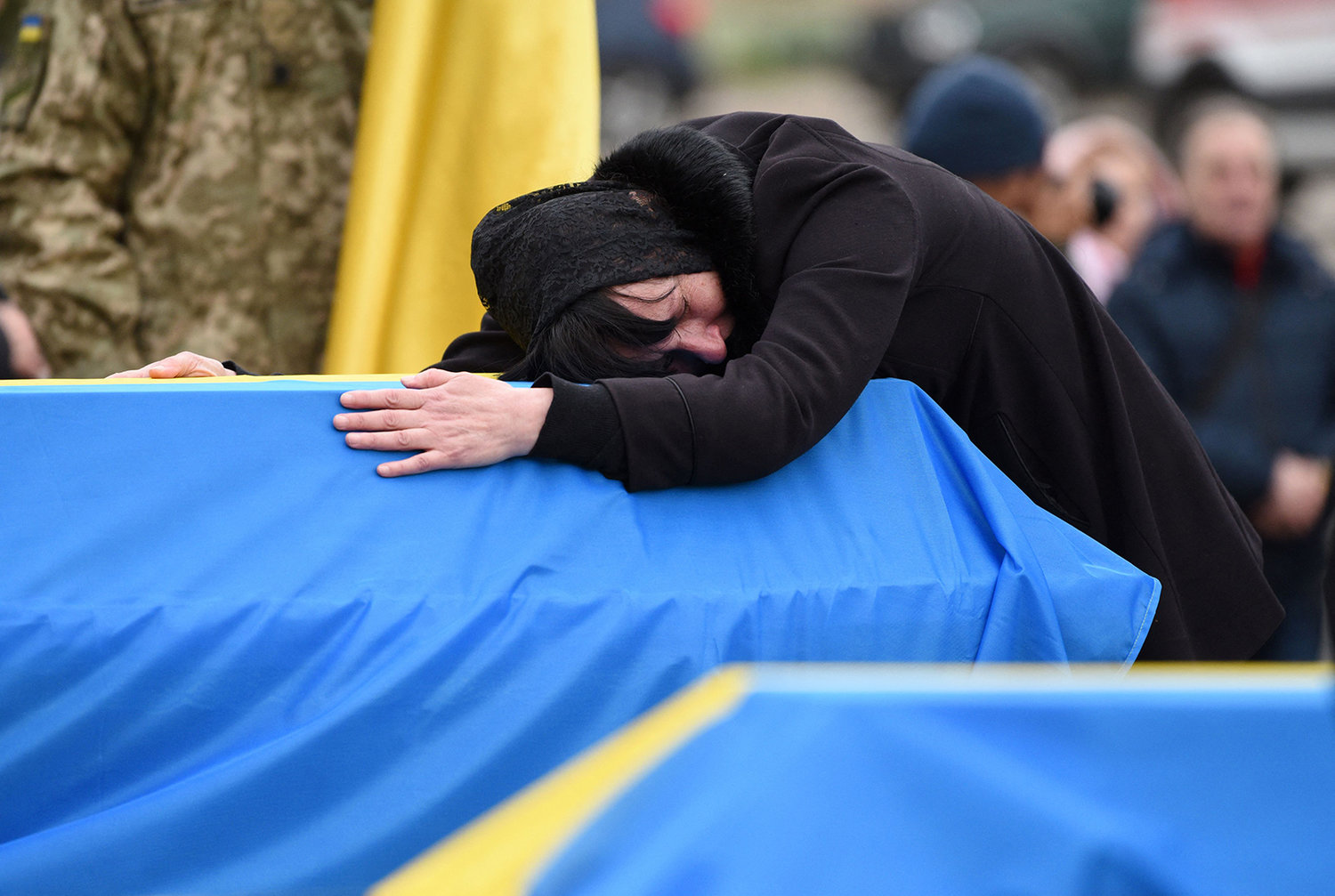 The mother of Ukrainian soldier Lubomyr Hudzeliak, who was killed during Russia's invasion of Ukraine, mourns over his flag-draped coffin during his funeral at the Lychakiv cemetery, in the western Ukrainian city of Lviv on April 6, 2022. Nearly 35,000 Ukrainians fled west in 24 hours to escape the Russian war in their country, the United Nations said on April 6, 2022, after Russia invaded Ukraine on Feb. 24, 2022. (Yuriy Dyachyshyn/AFP via Getty Images/TNS)