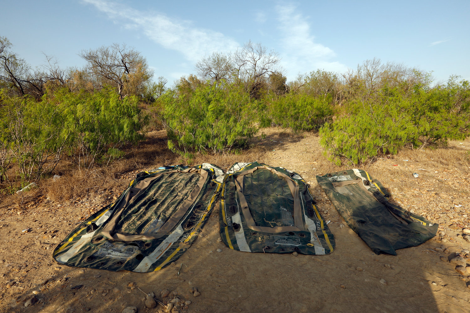 Three plastic rafts used by smugglers to get migrants across the Rio Grande River, later confiscated by Border Patrol agents, on March 22, 2021 in Roma, Texas. (Carolyn Cole/Los Angeles Times/TNS)