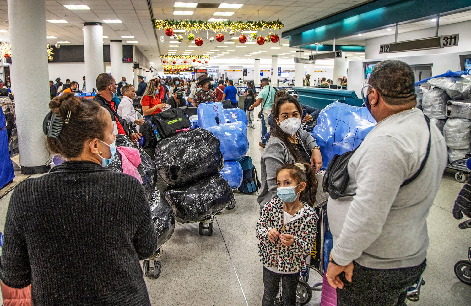 Travelers heading to Cuba are seen at Miami International Airport in December 2021. Cuba is dropping COVID restrictions for international travelers despite new surges around the world. Tourism to the Caribbean island took a big hit during the pandemic. (Pedro Portal/Miami Herald/TNS)