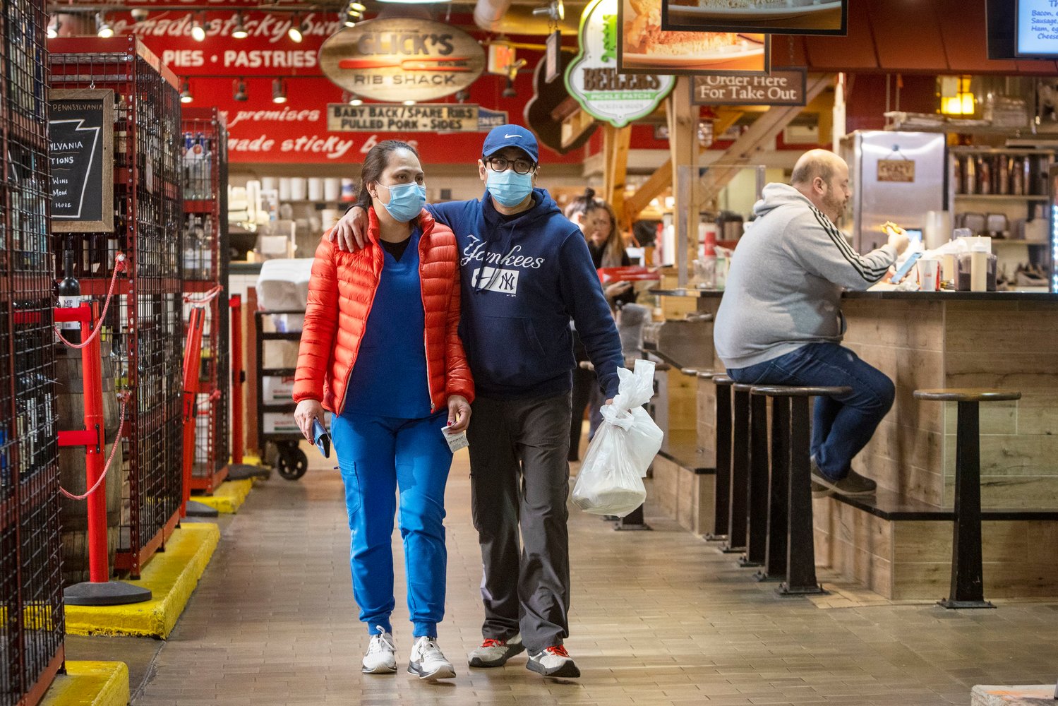 Shoppers wearing masks make their way through Reading Terminal Market in Center City. Indoor masking will be required in Philadelphia again next week, the city health department announced Monday. (Alejandro A. Alvarez/The Philadelphia Inquirer/TNS)