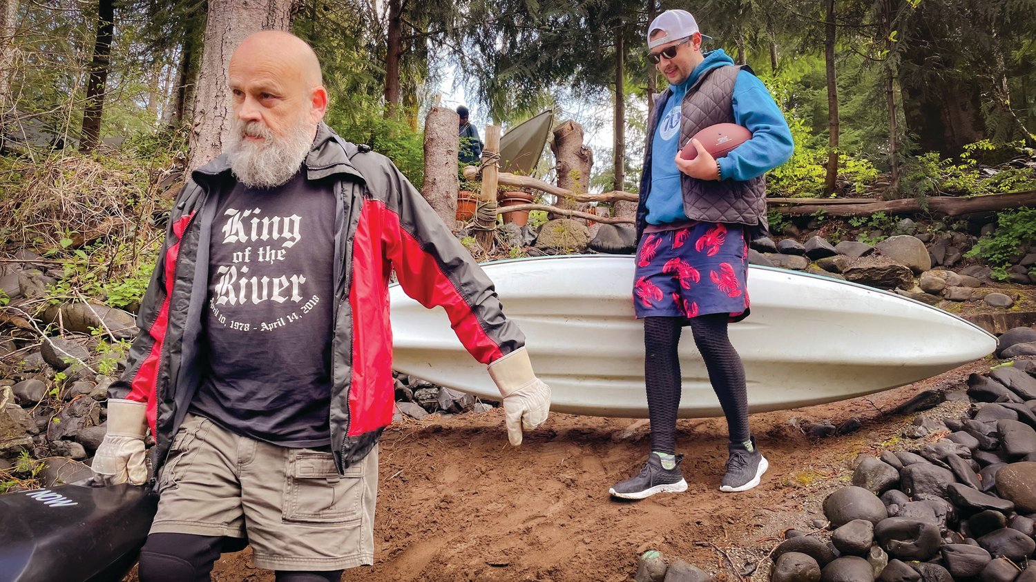 Jim Merrill, left, sports a shirt that reads, “King of the River,” during the Pe Ell River Run as he helps carry kayaks down to the Chehalis on Saturday.