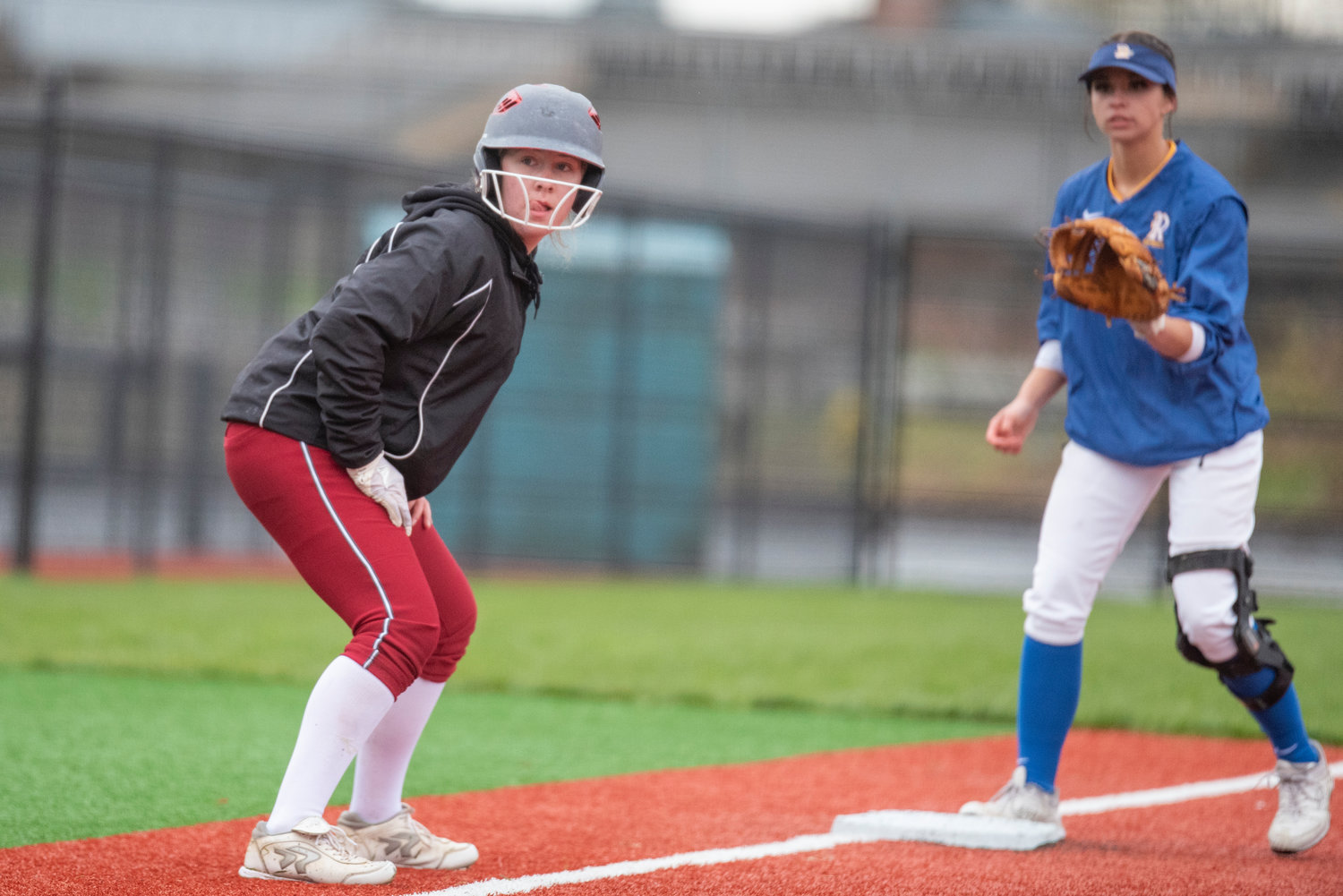 W.F. West's Lena Fragner watches home plate as Rochester third baseman Sadie Knutson covers third during a game at Chehalis Sports Complex on April 13.