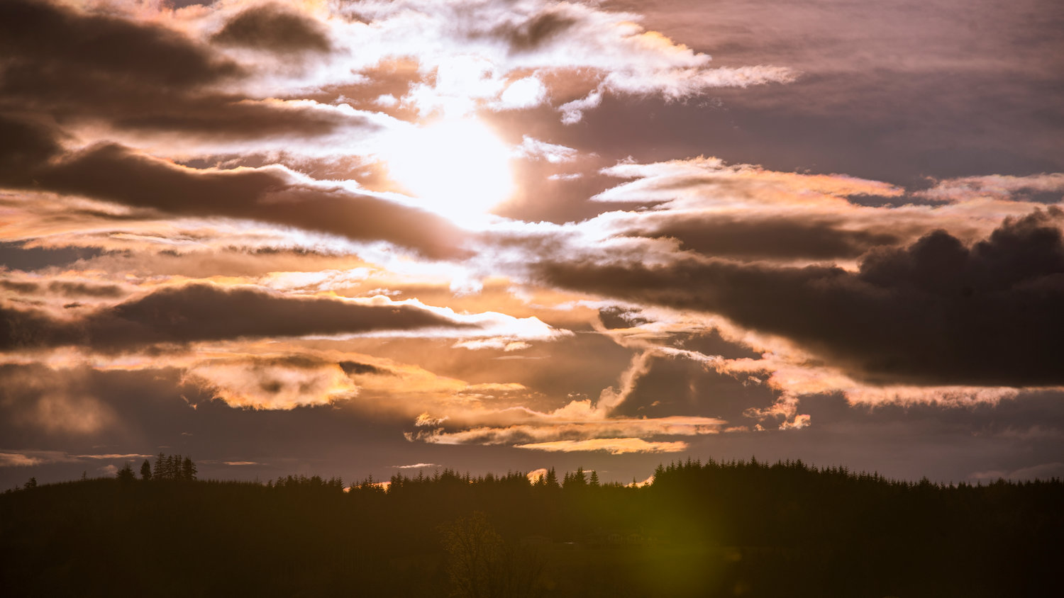 The sun sets through clouds over Chehalis on Thursday.