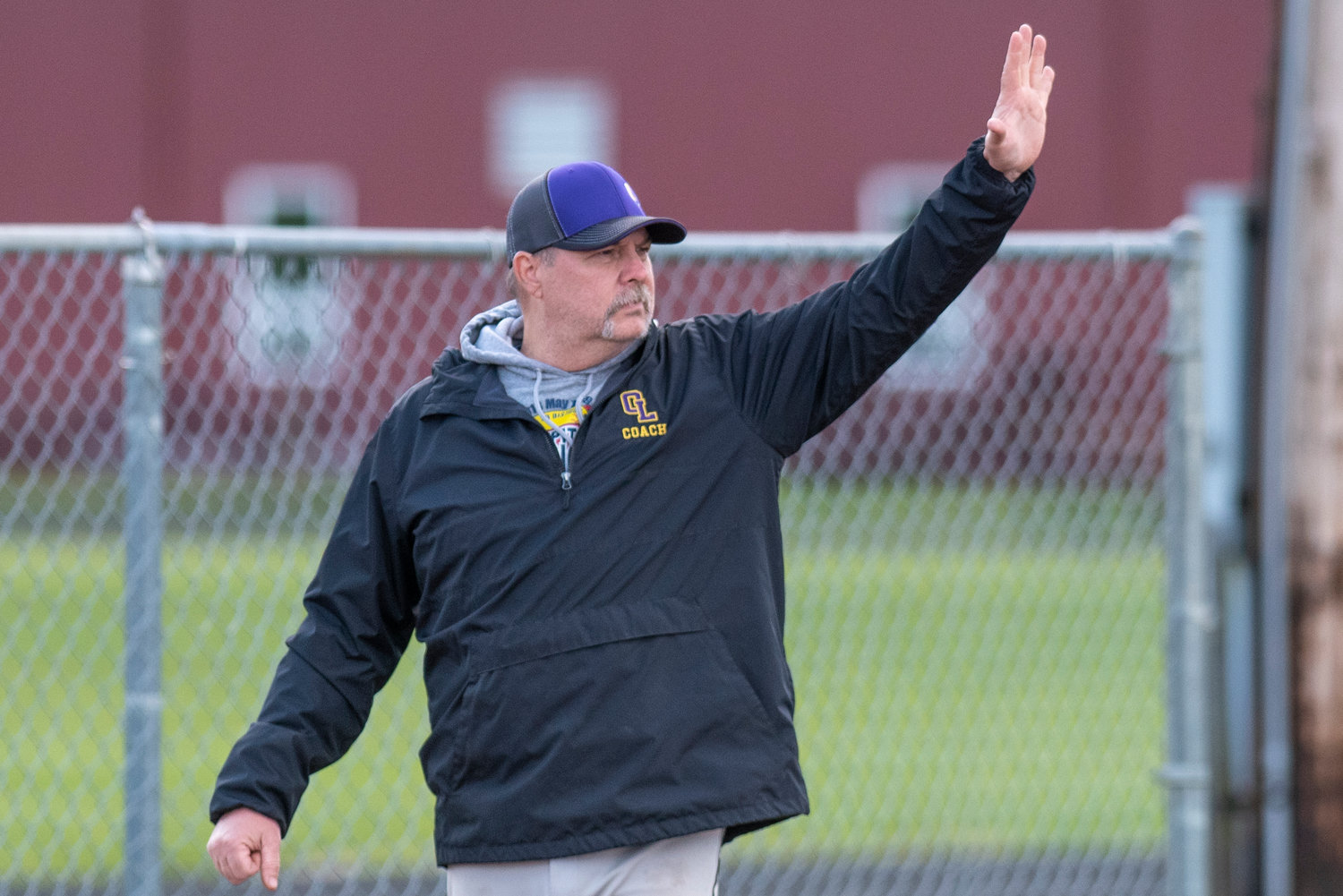 Onalaska softball coach Rich Teitzel signals to one of his baserunners during a home game against Mossyrock on April 15.