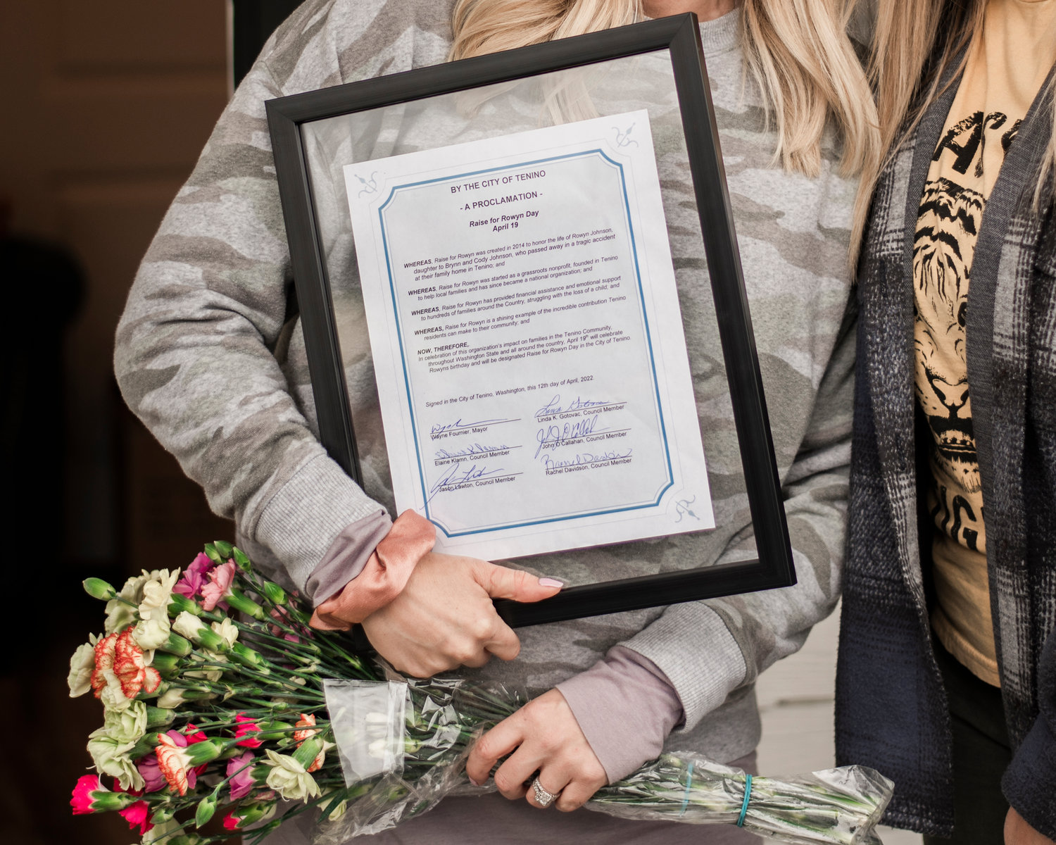 Brynn Johnson holds onto flowers and a proclamation by the City of Tenino Tuesday during an event honoring Raise for Rowyn Day in Tenino.