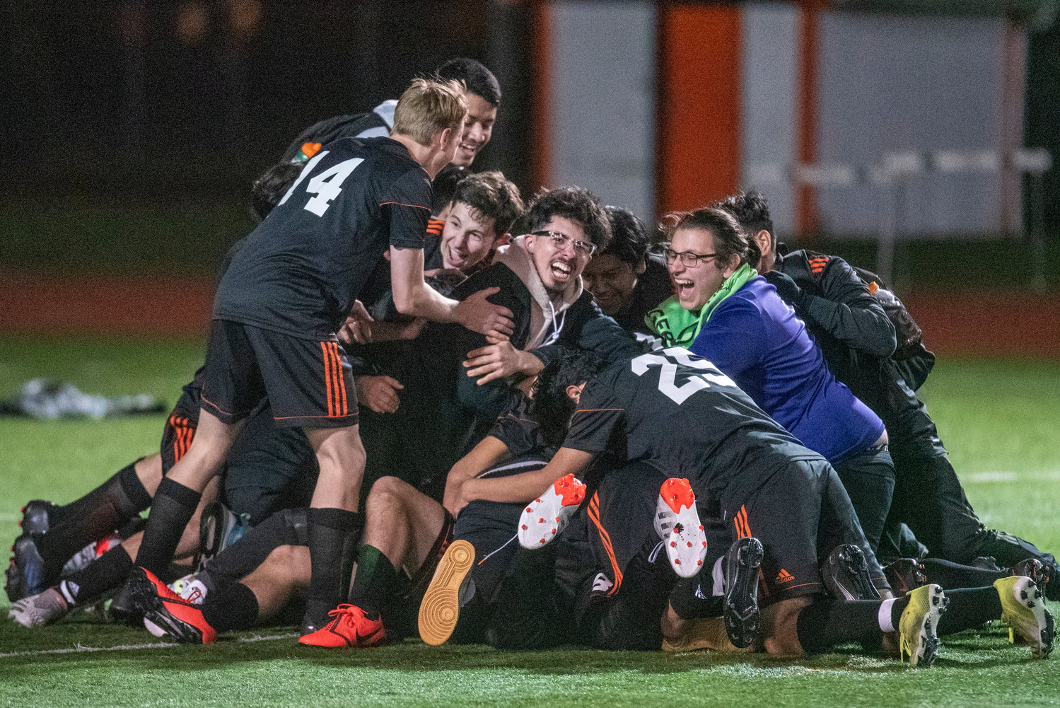 Centralia soccer players pile on Darrell Neuert after Neuert hit the Chronicle Cup-winning PK against W.F. West on April 22.