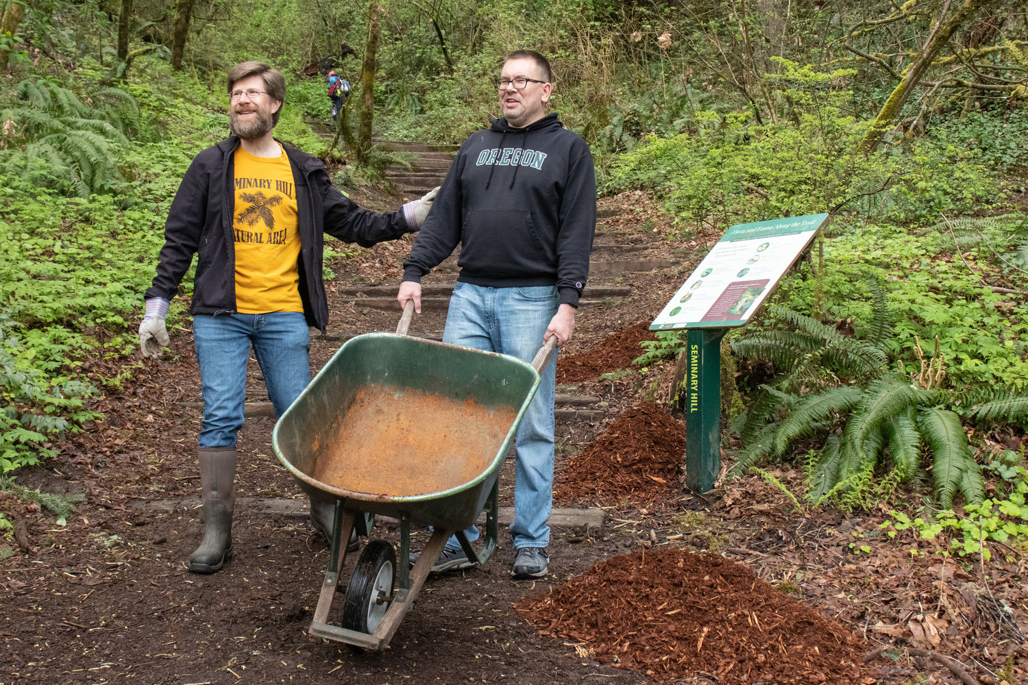 Brian Mittge and a volunteer unload bark chips on a trail during the Friends of the Seminary Hill Natural Area Earth Day Work Party in Centralia on Saturday.
