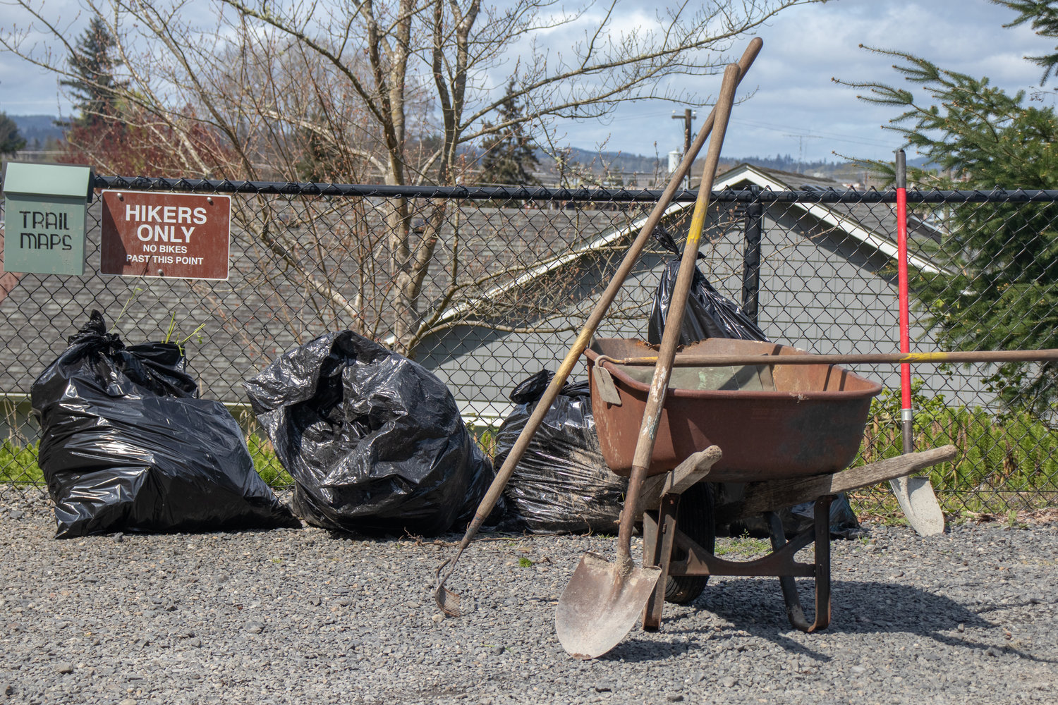 Tools and bags of debris rest against a fence at the Seminary Hill Natural Area in Centralia on Saturday.