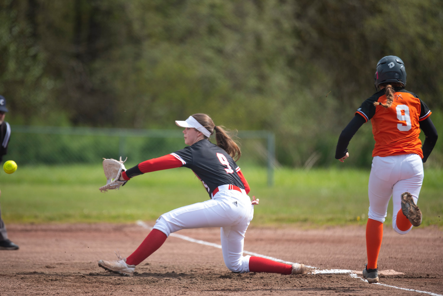 Toledo first baseman Averie Robins (9) stretches to catch a throw while Rainier's Dakota Anderson (8) sprints to first during a game on April 22.