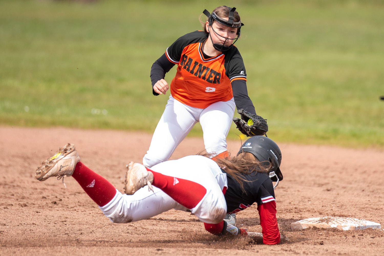 Rainier shortstop Brooklynn Swenson (9) tags Toledo's Averie Robins out on a steal attempt during a game in Toledo on April 25.