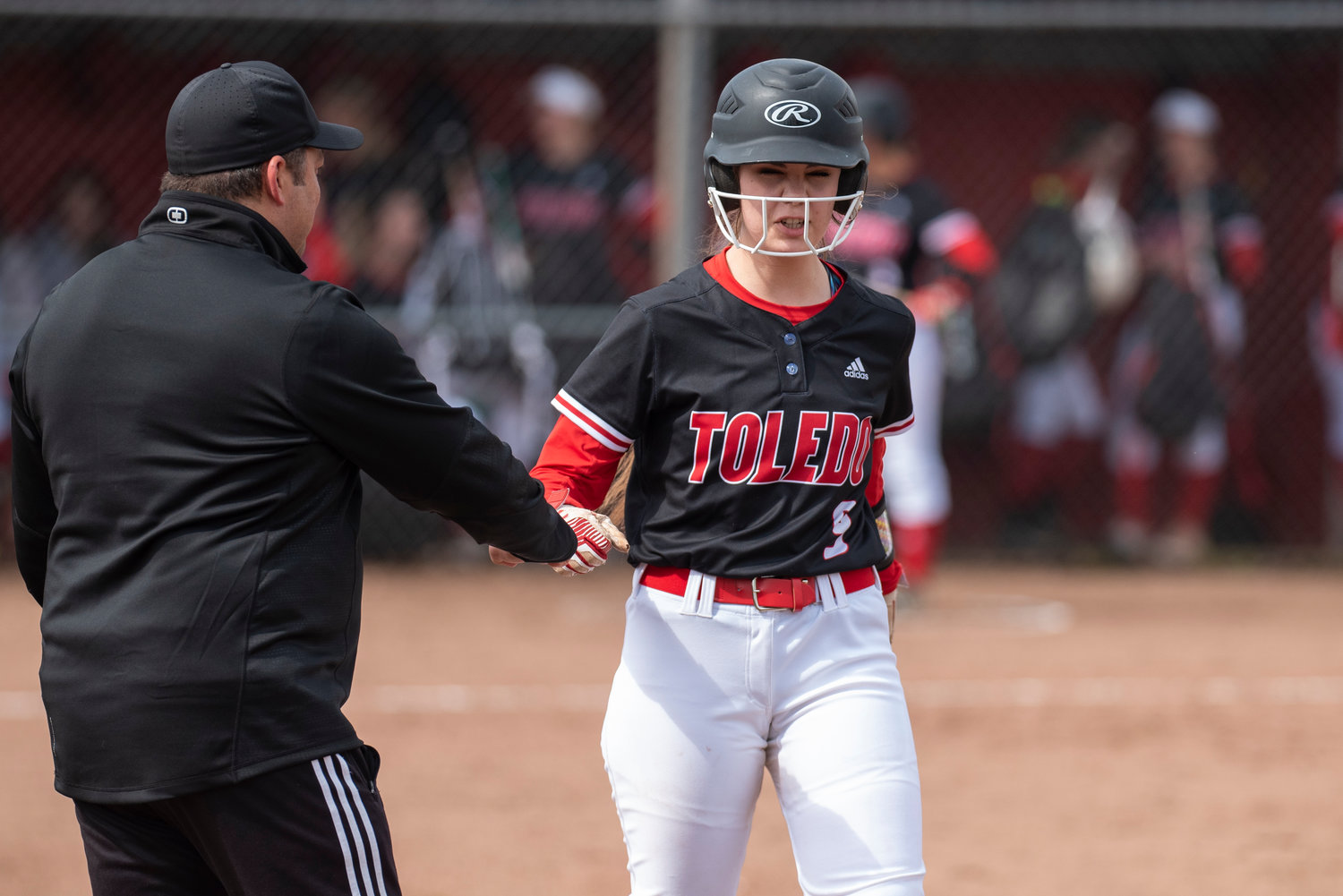 Toledo's Averie Robins, right, fist-bumps assistant coach Horst Malunat after being hit by a pitch during a home game against Rainier on April 25.