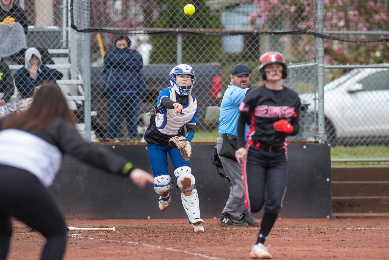 Elma's catcher makes a throw to first as Tenino's Kayla Feltus races to first base after laying down a bunt during a game in Tenino on April 26.